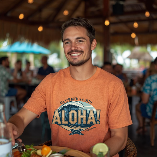 Man wearing an orange t-shirt with 'All you need is a little Aloha!' design in a casual setting.