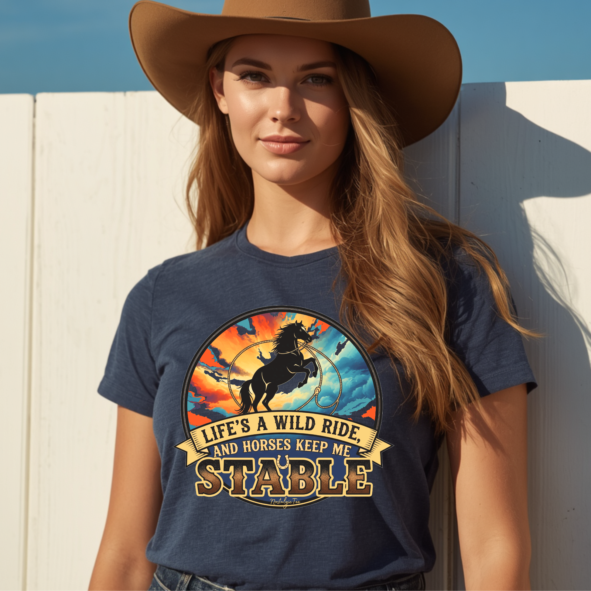A woman wearing a navy blue graphic t-shirt with a western-themed design that features a wild horse