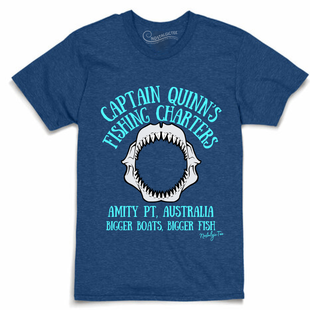 A heather blue crewneck t-shirt featuring a graphic print of a shark jaw with the text 'CAPTAIN QUINN'S FISHING CHARTERS' and 'AMITY PT, AUSTRALIA' in light blue and white.