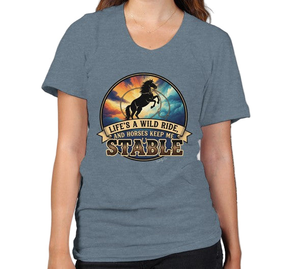 Woman wearing a blue t-shirt with a graphic design that says LIfe's a wild ride and horses keep me stable