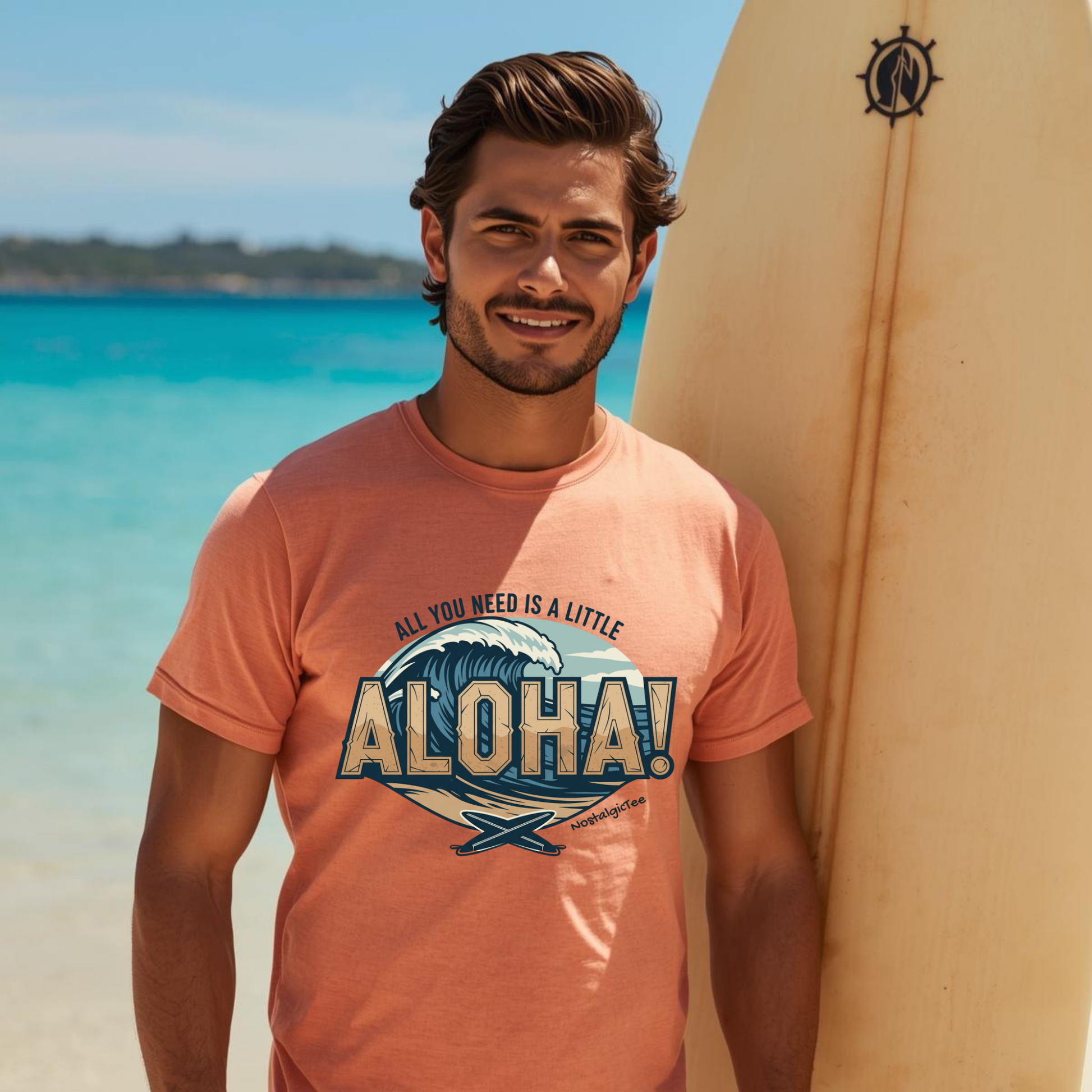 Man wearing a t-shirt with 'All you need is a little Aloha' design on a beach with surfboard.