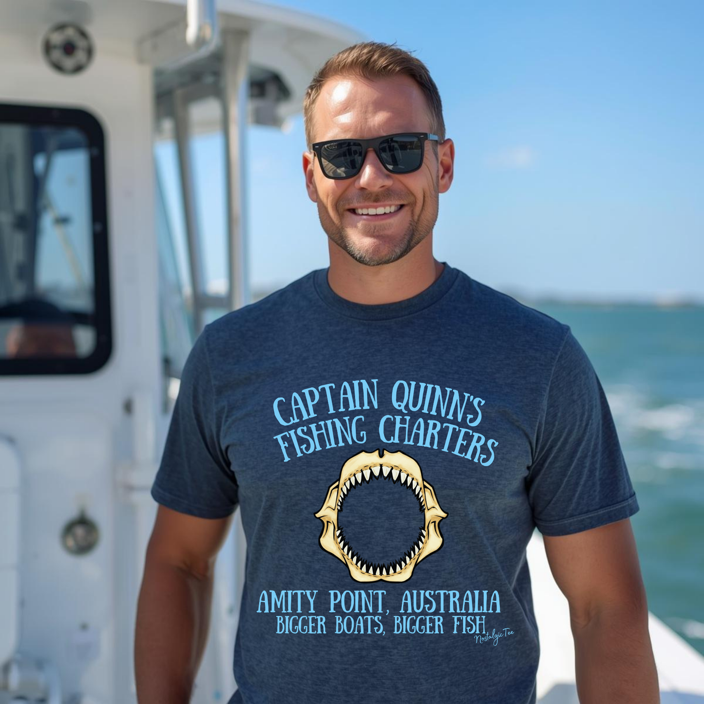 Man wearing a jaws captain quinns fishing charters top