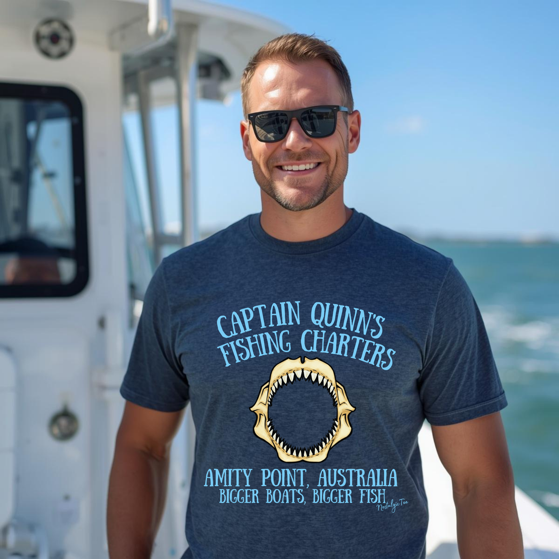 Man wearing a jaws captain quinns fishing charters top