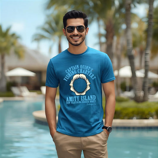 Man wearing a blue t-shirt with a graphic design, standing by a pool with palm trees in the background.
